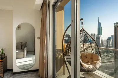 a room with a balcony with a chair and a window at Apartments in Address Dubai Marina Residences connected to Marina Mall in Dubai