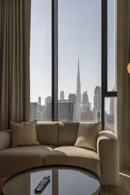 a living room with a couch and a large window at Business-Ready Executive Studio with Burj View in Dubai