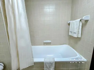 a bathroom with a tub and a shower curtain at Rare Holiday Homes - Mediterranean Cluster - Near Ibn Battuta Mall - Discovery Garden - Building# Med 49 - R213 in Dubai