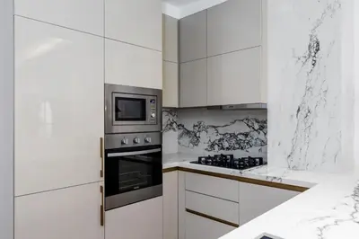a white kitchen with a stove and a microwave at Waves - Premium Seaside Retreat With Private Beach in Dubai