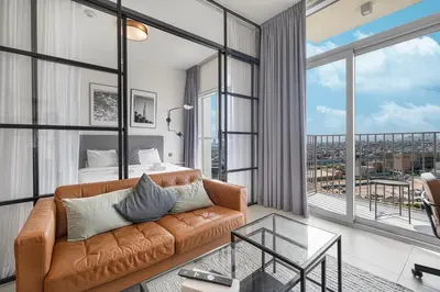 a living room with a couch and a bed at Cozy 1BR Near Dubai Hills Park in Dubai