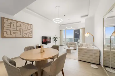 a living room with a table and chairs and a couch at Elegant 1 BR Apartment near Mall of the Emirates in Dubai