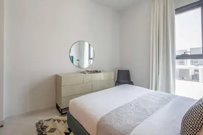 a bedroom with a bed and a mirror on a dresser at Frank Porter - La Rosa 6 in Dubai