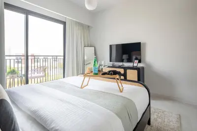 a bedroom with a bed with a television and a balcony at Frank Porter - La Rosa 6 in Dubai