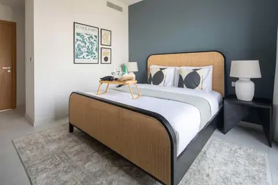a bedroom with a large bed with a side table at Frank Porter - La Rosa 6 in Dubai
