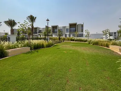 a large grassy yard in front of a building at Frank Porter - La Rosa 6 in Dubai