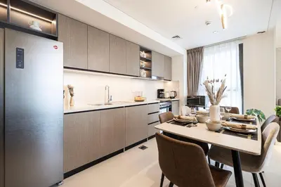 a kitchen and dining room with a table and chairs at City Views, Pool & Gym Near Iconic Burj Khalifa in Dubai