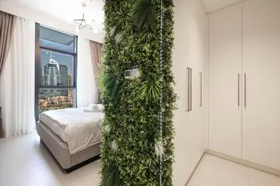a bedroom with a green wall with a bed at City Views, Pool & Gym Near Iconic Burj Khalifa in Dubai