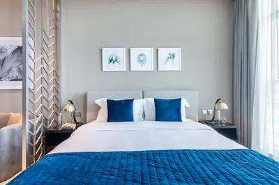 a bedroom with a large bed with blue pillows at Luxurious Studio in Heart of Business Bay in Dubai