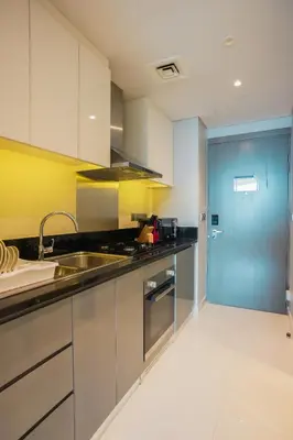 a kitchen with stainless steel appliances and a blue door at Luxurious Studio in Heart of Business Bay in Dubai