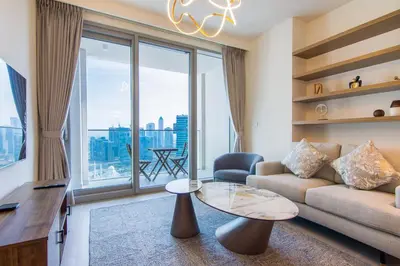 a living room with a couch and a glass table at Forte, Downtown- Elegant 1-BR in Dubai