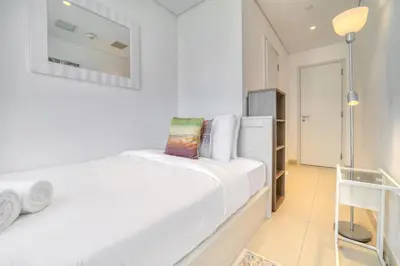 a white bedroom with a bed and a mirror at Shadow Of The Sun by Lagom in Dubai