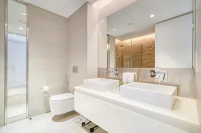 a bathroom with two sinks and a toilet and a mirror at Shadow Of The Sun by Lagom in Dubai