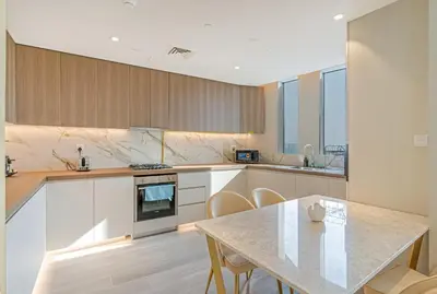 a kitchen with a table and a table and chairs at Savis Homes - Condor Marina Star - Luxury 2 BR Waterfront Apartment in Dubai