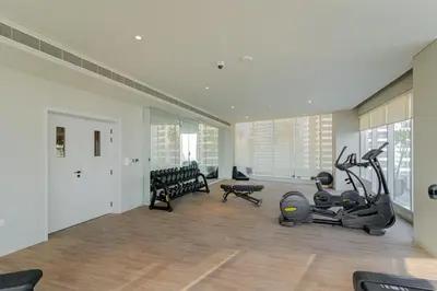 a gym with two exercise bikes and a treadmill at Savis Homes - Condor Marina Star - Luxury 2 BR Waterfront Apartment in Dubai