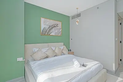 a bedroom with a large bed with blue walls at Savis Homes - Condor Marina Star - Luxury 2 BR Waterfront Apartment in Dubai