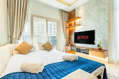 a hotel room with a bed and a tv at Deluxe One-Bedroom Apartment in Business Bay with Burj Khalifa and Canal View in Dubai
