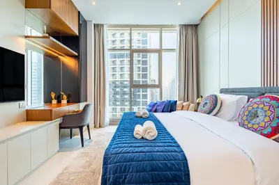 a hotel room with a large bed and a desk at Deluxe One-Bedroom Apartment in Business Bay with Burj Khalifa and Canal View in Dubai
