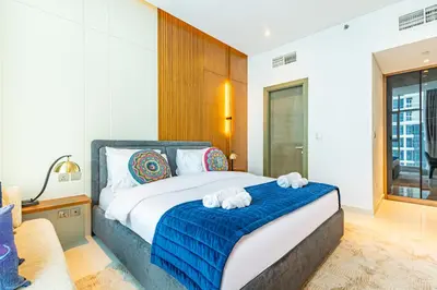a bedroom with a bed with two towels on it at Deluxe One-Bedroom Apartment in Business Bay with Burj Khalifa and Canal View in Dubai