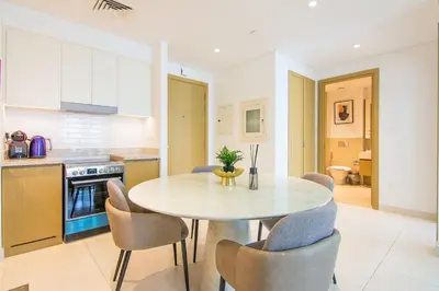 a kitchen and dining room with a table and chairs at Creekside, Creek Harbour 1 BDR in Dubai