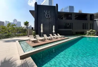 a swimming pool with lounge chairs next to a building at Spacious 1br in Ahad, Business Bay in Dubai