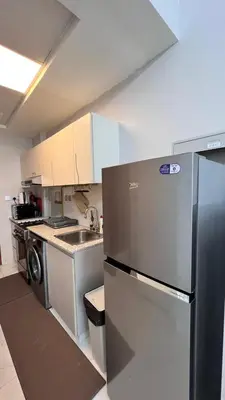 a kitchen with a stainless steel refrigerator and a dishwasher at Millennium Binghatti Residence in Dubai