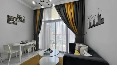 a living room with a couch and a table and a window at Millennium Binghatti Residence in Dubai