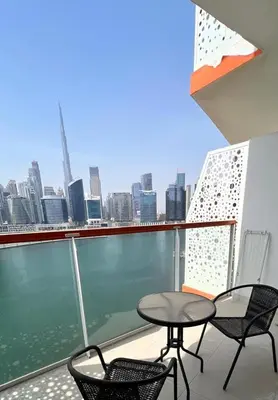 a balcony with a table and chairs and a view of the city at Millennium Binghatti Residence in Dubai