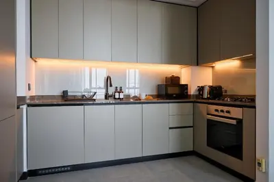 a kitchen with white cabinets and a counter top at Luxury 1Br apartment, Canal view in Dubai