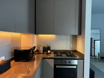 a kitchen with a stove top oven next to a microwave at Luxury 1Br apartment, Canal view in Dubai
