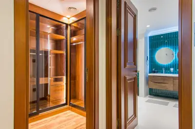 a walk in closet with wooden panels and a glass door at Fairmont Residences, Exquisite 2BR Luxury Retreat in Dubai
