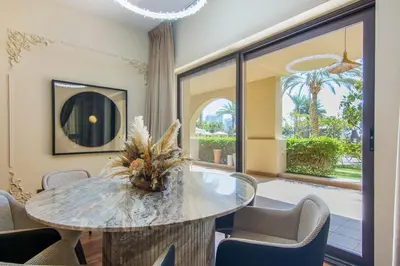 a dining room with a glass table and chairs at Fairmont Residences, Exquisite 2BR Luxury Retreat in Dubai