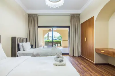 a hotel room with two beds and a chandelier at Fairmont Residences, Exquisite 2BR Luxury Retreat in Dubai