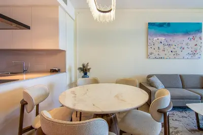 a kitchen and living room with a table and chairs at Address Residential 2 BDR, JBR in Dubai
