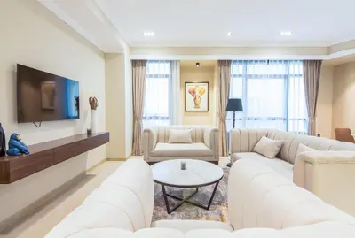 a living room with white furniture and a tv at Marina Crown 2 BDR, Marina in Dubai