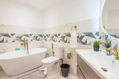 a bathroom with a tub and a toilet and a sink at Marina Crown 2 BDR, Marina in Dubai