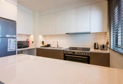 a kitchen with white cabinets and a sink and a stove at Reem 3 BDR Villa in Dubai