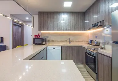 a large kitchen with wooden cabinets and a counter top at MBL Residence 2 BDR, JLT in Dubai