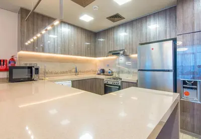 a large kitchen with a refrigerator and a stove at MBL Residence 2 BDR, JLT in Dubai