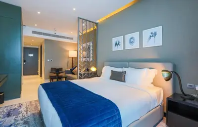 a bedroom with a large bed with a blue blanket at Damac Maison Prive, Business Bay- Gorgeous Studio in Dubai