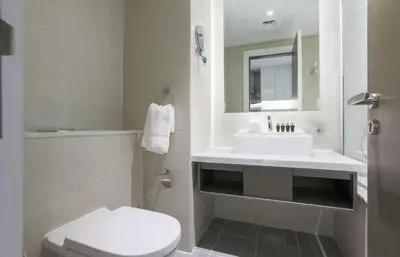 a white bathroom with a sink and a toilet at Damac Maison Prive, Business Bay- Gorgeous Studio in Dubai