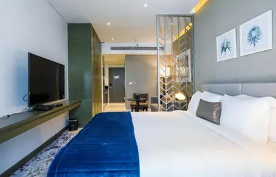a hotel room with a large bed and a flat screen tv at Damac Maison Prive, Business Bay- Gorgeous Studio in Dubai