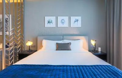 a bedroom with a large bed and two lamps at Damac Maison Prive, Business Bay- Gorgeous Studio in Dubai