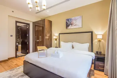 a bedroom with a large white bed in a room at Elite 1 BR, Downtown in Dubai