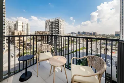 a balcony with chairs and a table and a view of a city at Premium Apartments at Executive Residences in Dubai