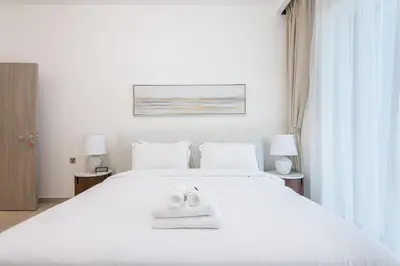 a bedroom with a white bed with shoes on it at Me Do Re1BR, JLT in Dubai