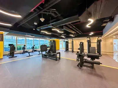 a gym with several rows of treadmills and machines at Me Do Re1BR, JLT in Dubai