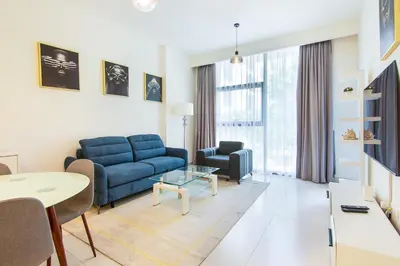 a living room with a blue couch and a table at Park Point 1 BR, Dubai Hills in Dubai