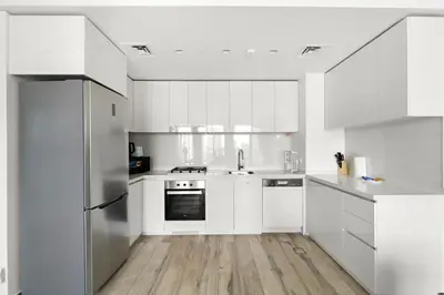 a white kitchen with a sink and a refrigerator at StoneTree - Newly Furnished - Stylish in Dubai