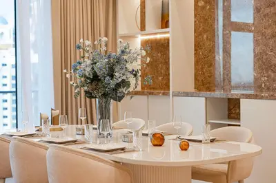 a long table with chairs and a vase of flowers at Daniels Full Sea View 3BR in Oceana Atlantic in Dubai